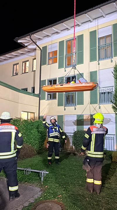 Feuerwehrleute im Außenbereich mit Trage
